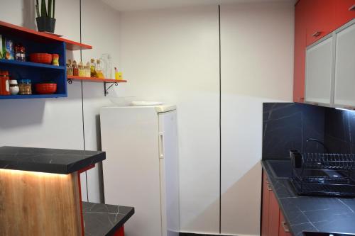 a kitchen with a white refrigerator and a black counter at Montenegro Backpackers Home Budva in Budva