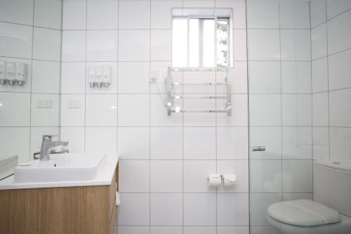 a white bathroom with a sink and a toilet at Ocean Front Motel in The Entrance