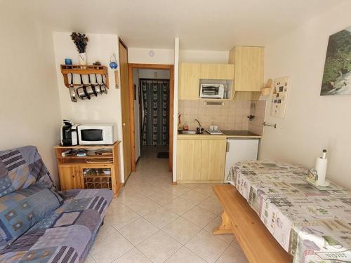 un salon avec un canapé et une cuisine dans l'établissement Studio 25m² au pied des montagnes, balcon, idéal pour 4 pers - FR-1-573-95, à Le Biot