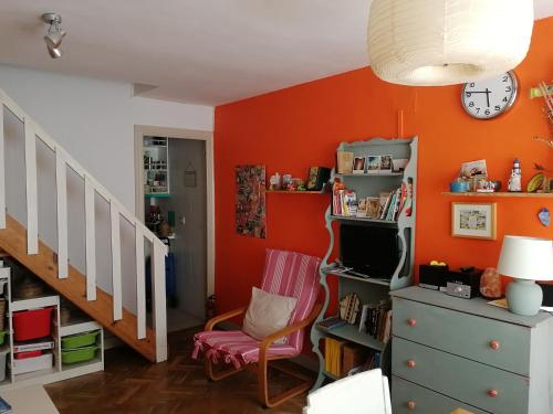 uma sala de estar com paredes cor de laranja e uma cadeira em Casita em Madri