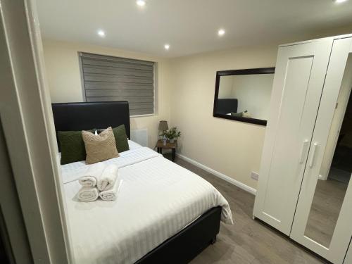 a bedroom with a bed with shoes on it at The Cosy Cottage, Old Soles bridge Lane in Chorleywood