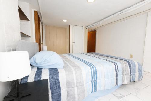 澤西城的住宿－3-Bed Luxurious Home Close to NYC，一间卧室配有一张带蓝白色毯子的床