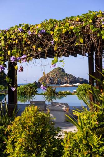 a pergola filled with plants and flowers at Ocean Front Luxury - 5 Pools & Private Beach Club in Careyes