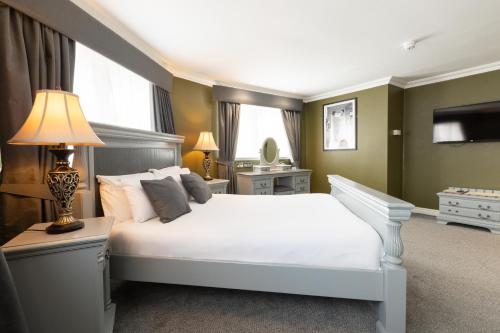 a bedroom with a white bed and a lamp at The Sir Thomas Hotel in Liverpool