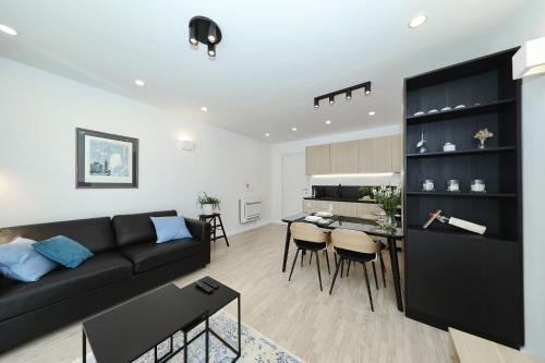 a living room with a black couch and a kitchen at Sidra city apartment in Zadar
