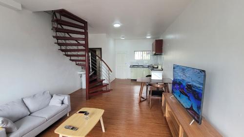 - un salon avec un canapé et un escalier dans l'établissement Easy Apt, à Suva