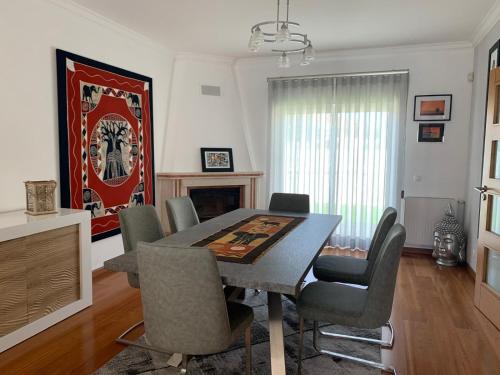 a dining room with a table and chairs at Villa Luxsomar in Charneca