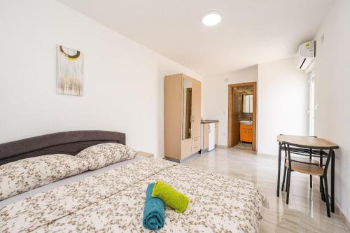 a bedroom with a bed and a table and a chair at Apartments and Rooms STIPANOVI DVORI in Donji Karin