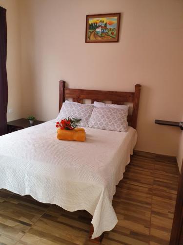 Un dormitorio con una cama con sábanas blancas y flores. en Villas Bahía Salinas, en La Cruz