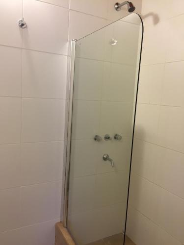 a shower with a glass door in a bathroom at Ukurj Apartamentos in Ushuaia