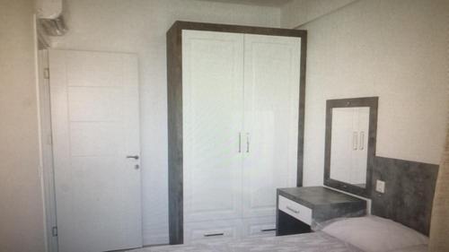 1 dormitorio con espejo, 1 cama y vestidor en Garden De Padre, en Antalya