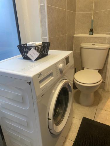 a bathroom with a washing machine and a toilet at Studio flat/Close to central in Hendon