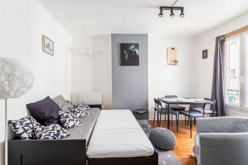 ein Wohnzimmer mit einem Sofa und einem Tisch in der Unterkunft Le Grey Cocon - Studio cosy aux portes de Paris in Saint-Mandé
