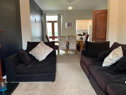 a living room with two couches and a dining room at Beautifully Styled 2BR Home with Garden in Manchester
