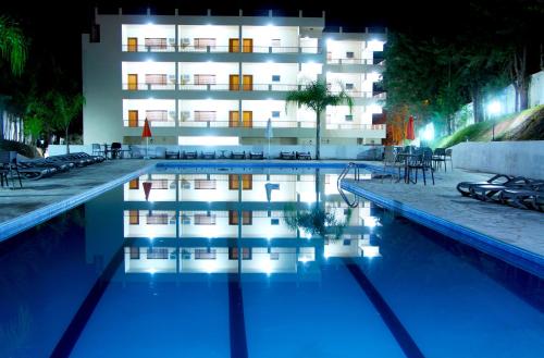 um hotel com piscina em frente a um edifício em Hotel Fazenda Pirâmides em Atibaia