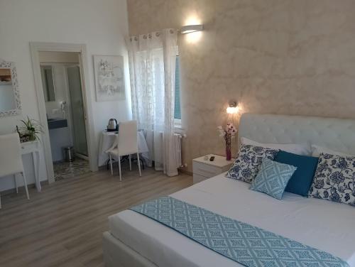 a bedroom with a white bed and a dining room at Viola di Mare Rooms and Parking in Termoli