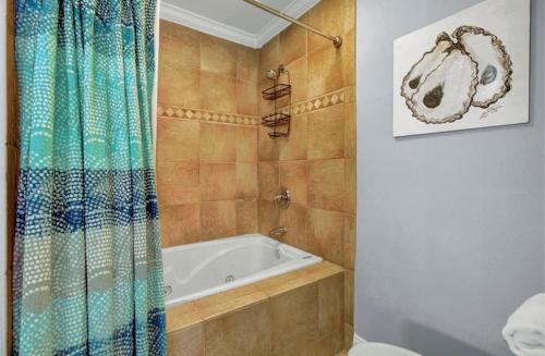 La salle de bains est pourvue d'une baignoire et d'un rideau de douche. dans l'établissement 113 Seascape by AvantStay Amazing Ocean Views Communal Pool, à Isle of Palms