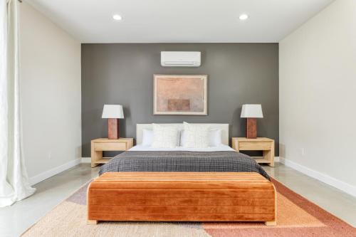 Ishan by AvantStay Designer Joshua Tree Oasis في يوككا فالي: غرفة نوم مع سرير مع مصباحين على جانبي