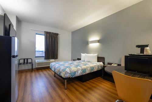 a hotel room with a bed and a television at Motel 6 Texas City I-45 in Texas City
