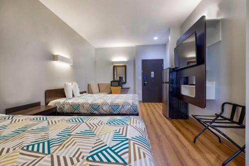 a hotel room with two beds and a flat screen tv at Motel 6 Texas City I-45 in Texas City