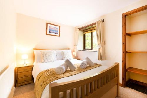 um quarto com uma cama grande e almofadas brancas em Mill Wheel Tower House @TheHomeAwaySouth em Combe Martin