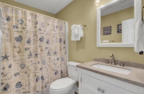a bathroom with a toilet and a sink and a shower curtain at 15 Lake Village by AvantStay Golf Course Lagoon Views in Isle of Palms