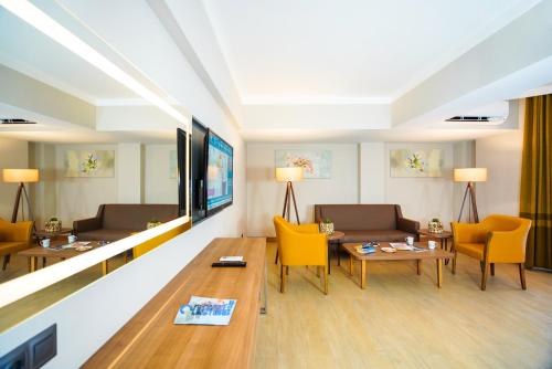 a living room with yellow chairs and a table at Ada Julian Marmaris in Marmaris