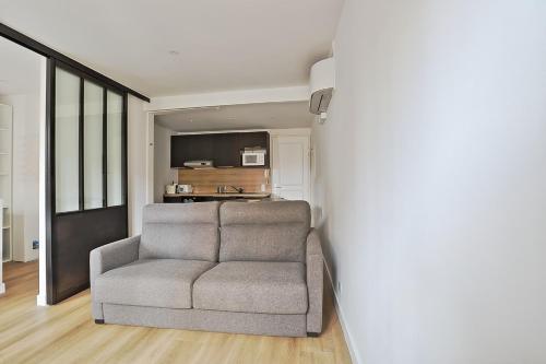 un salon avec une chaise et une cuisine dans l'établissement Appartement Gambetta - Welkeys, à Biarritz