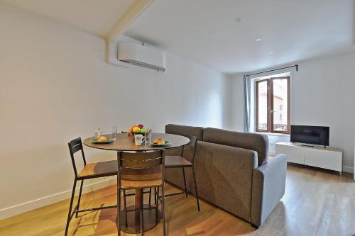 un salon avec une table, des chaises et un canapé dans l'établissement Appartement Gambetta - Welkeys, à Biarritz