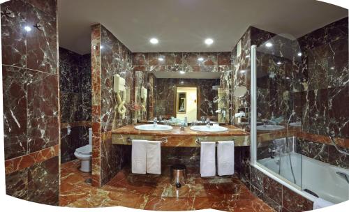 a large bathroom with two sinks and a shower at Parador de Zamora in Zamora