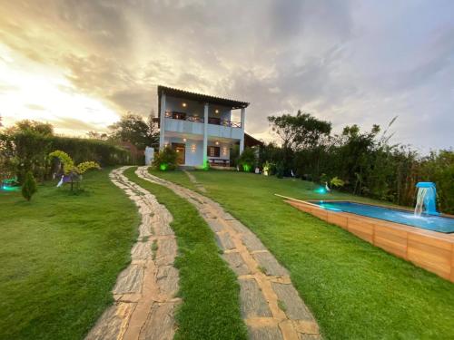 ein Haus mit einem Garten und einem Pool in der Unterkunft Chalé luz da Serra in Mulungu
