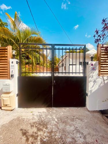 a black gate in a driveway with a house at Kay Alice - Beachfront Villa in Le Carbet