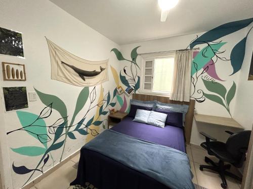 sypialnia z łóżkiem z kolorowymi liśćmi na ścianie w obiekcie Guest House Vida Vibra w mieście Ubatuba