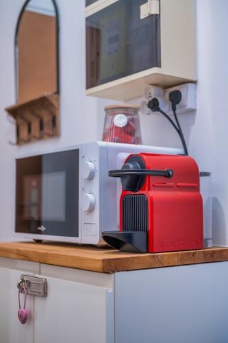 un grille-pain rouge assis sur un comptoir à côté d'un four micro-ondes dans l'établissement Studio Boulingrin - Hypercentre, à Reims