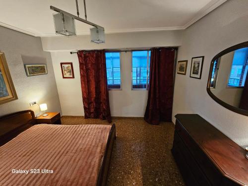 グラオ・デ・カステヨンにあるFelicidad del marのベッドルーム1室(ベッド1台、窓2つ、鏡付)
