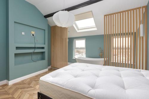ein Schlafzimmer mit einem großen weißen Bett und einer Badewanne in der Unterkunft 4br house - close to attractions in Blackpool