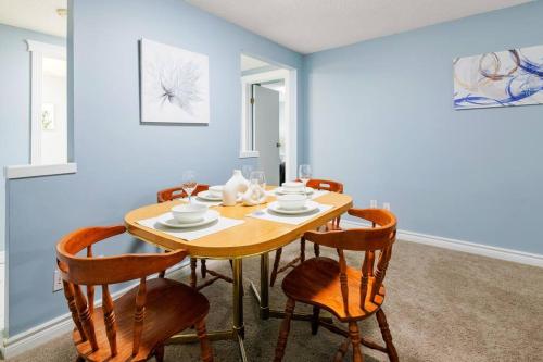 a dining room with a wooden table and chairs at Cozy Suite - Walk to West Ed Mall in Edmonton