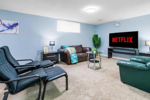 a living room with a couch and a tv at Cozy Suite - Walk to West Ed Mall in Edmonton