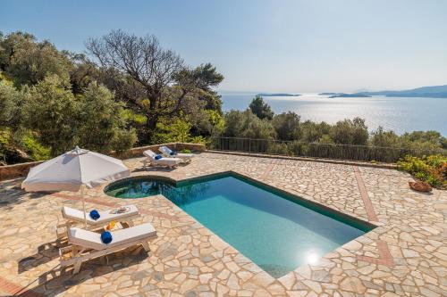 a swimming pool with two chairs and an umbrella at RODON Luxury Villas in Skopelos Town