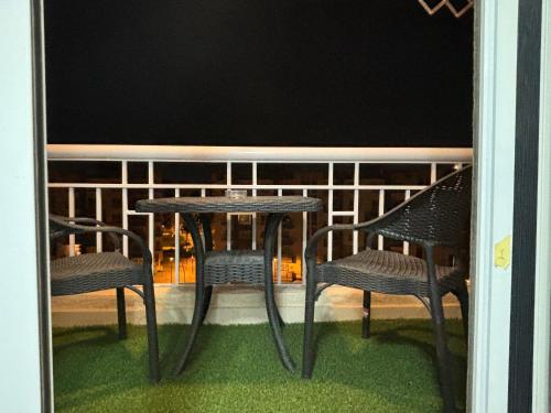 a table and two chairs on a balcony at night at Luxury Inn: 2BR Prime location in Madinaty B12 in Madinaty