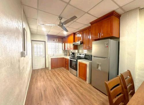 uma cozinha com armários de madeira e um frigorífico de aço inoxidável em Casa moderna a la vuelta de metrocentro San Miguel em San Miguel