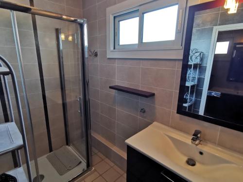 une salle de bain avec une douche en verre et un lavabo dans l'établissement Le Grand Panoramique - Face Mer, à Les Sables-dʼOlonne