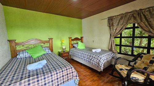 a bedroom with two beds and a window at Paraíso en Atitlán in Panaranjo