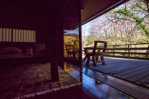 a room with a balcony with a table and chairs at Satonoyu Waraku 13 years or older in Minamioguni
