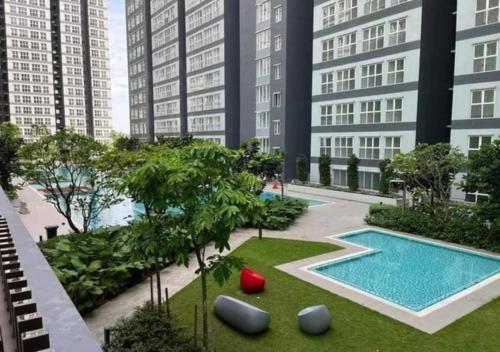 an apartment complex with a swimming pool and tall buildings at Canopy Hills Residensi Rimbun in Kajang