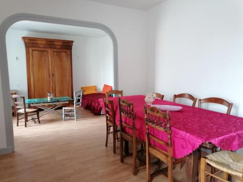 une salle à manger avec une table et des chaises roses dans l'établissement Location meublé non professionnels, à Bains
