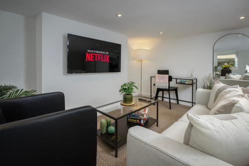 a living room with a couch and a tv on the wall at Blackpool Central Springfield Apartments Spacious Comfort in Blackpool