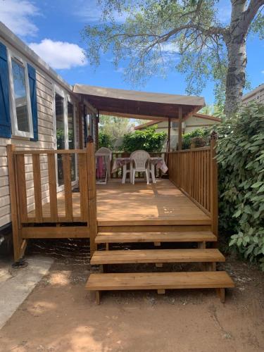 eine Holzterrasse mit Pavillon in der Unterkunft Mobil-home bord de mer in Vendres