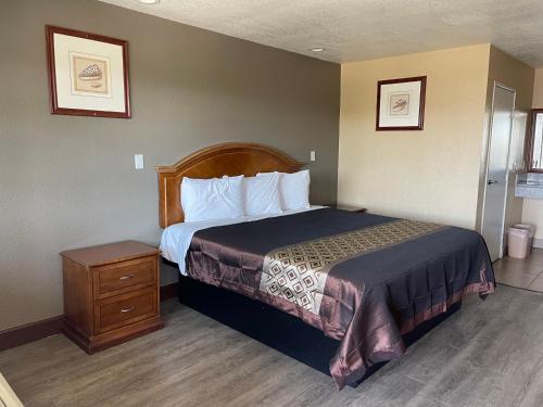 um quarto de hotel com uma cama e uma mesa de cabeceira em Arlington Inn em Riverside
