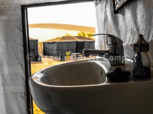 lavabo en el baño con vistas a la playa en Acacia Desert Camp, en Merzouga